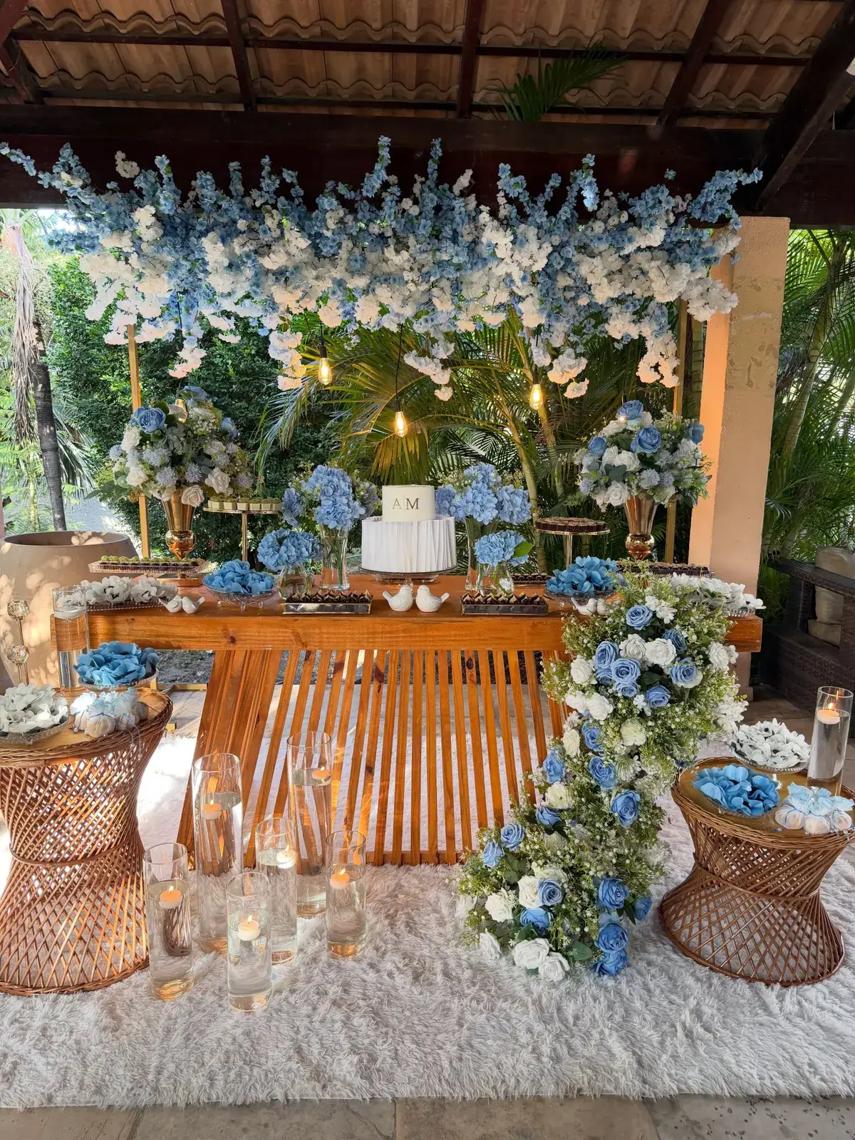 Decoração azul e branca com flores, mesa de doces e velas
